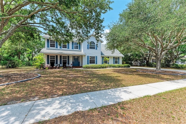 colonial-style house with a porch and a front lawn