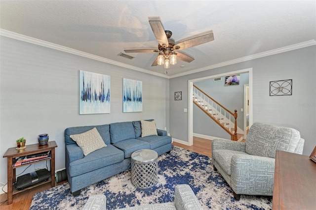 living room with ornamental molding, a textured ceiling, hardwood / wood-style flooring, and ceiling fan