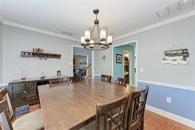 dining space featuring ornamental molding, a chandelier, wood-type flooring, and a textured ceiling