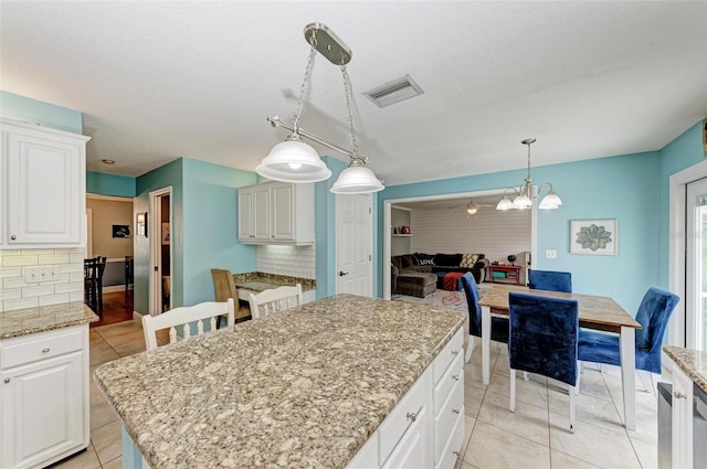 kitchen with backsplash, a center island, hanging light fixtures, and white cabinets