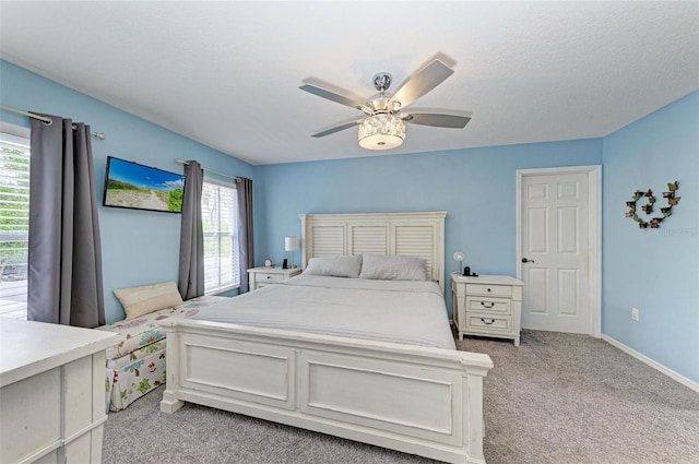 carpeted bedroom featuring ceiling fan and a textured ceiling