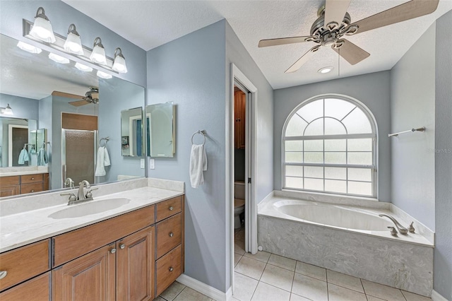 full bathroom featuring separate shower and tub, a textured ceiling, toilet, vanity, and tile patterned flooring