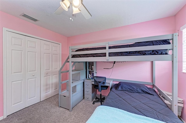 bedroom featuring light carpet, a textured ceiling, a closet, and ceiling fan