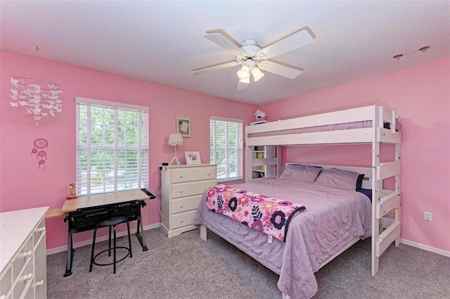 bedroom featuring a textured ceiling, light colored carpet, and ceiling fan