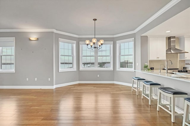 dining space featuring a chandelier, light wood-type flooring, and ornamental molding