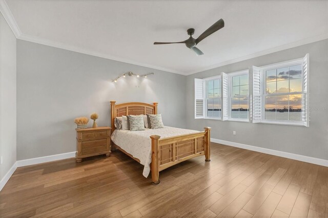 bedroom featuring ceiling fan, hardwood / wood-style floors, and ornamental molding