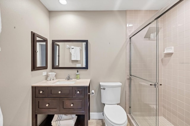 bathroom featuring vanity, toilet, and an enclosed shower