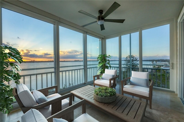 sunroom / solarium featuring ceiling fan and a water view