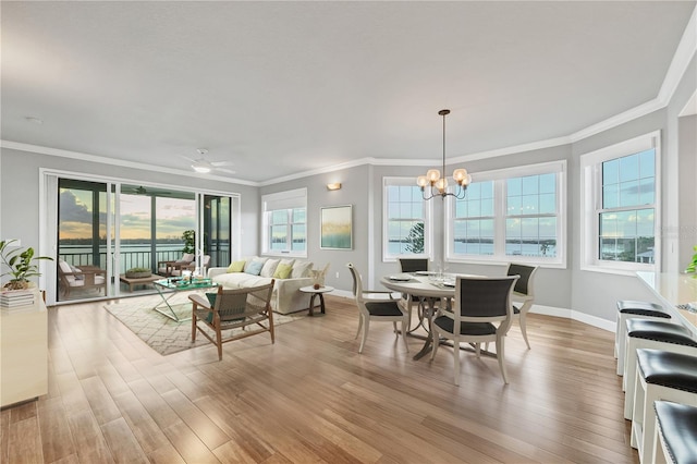 dining area featuring light hardwood / wood-style floors, ceiling fan with notable chandelier, and ornamental molding