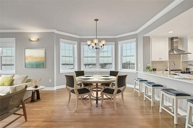 dining room with ornamental molding, light hardwood / wood-style flooring, and a notable chandelier