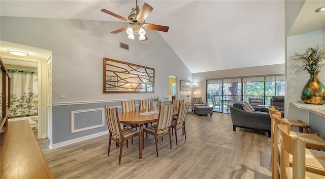 dining room featuring high vaulted ceiling, light wood-type flooring, and ceiling fan