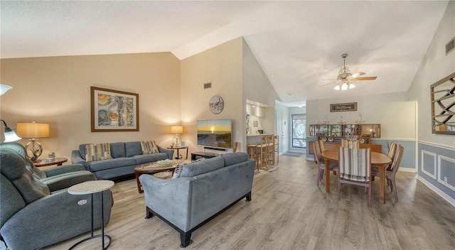 living room with high vaulted ceiling, light wood-type flooring, and ceiling fan