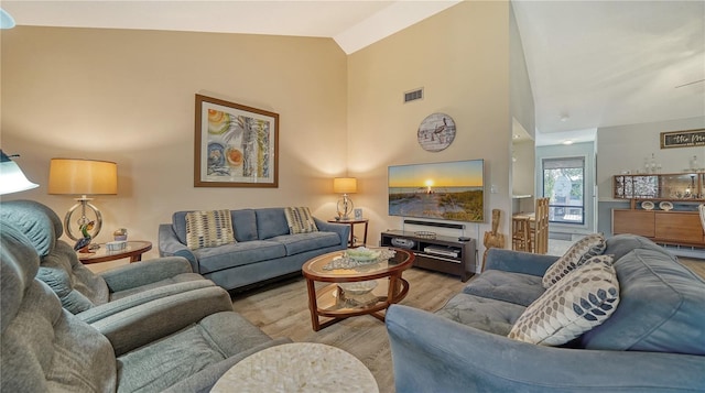 living room with light hardwood / wood-style flooring and vaulted ceiling