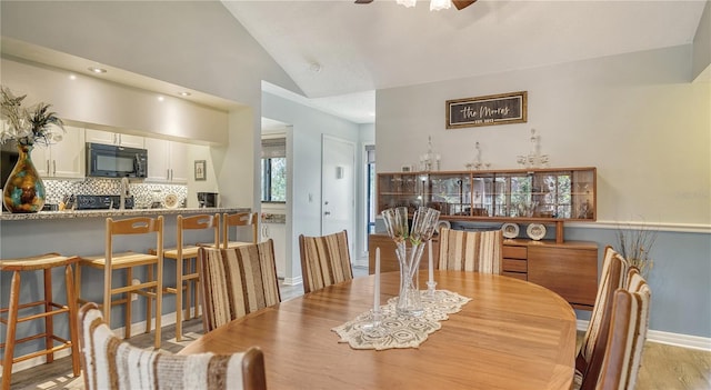 dining room featuring lofted ceiling, light wood-type flooring, and ceiling fan