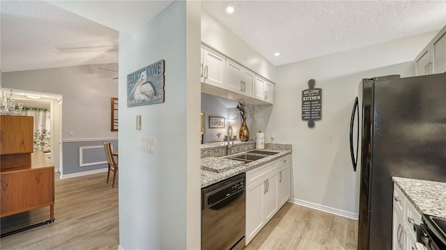 kitchen featuring white cabinetry, black appliances, sink, and vaulted ceiling