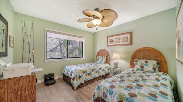 bedroom featuring a textured ceiling, light wood-type flooring, and ceiling fan