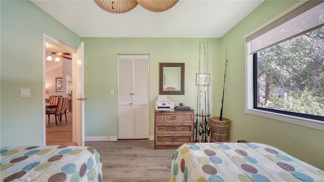 bedroom with a closet, light wood-type flooring, and ceiling fan