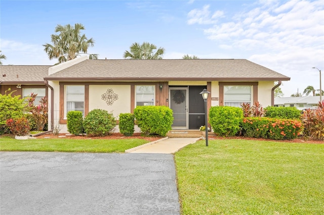 single story home featuring a front lawn