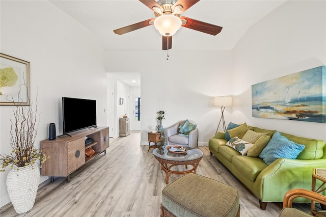 living room featuring light hardwood / wood-style flooring, ceiling fan, and vaulted ceiling