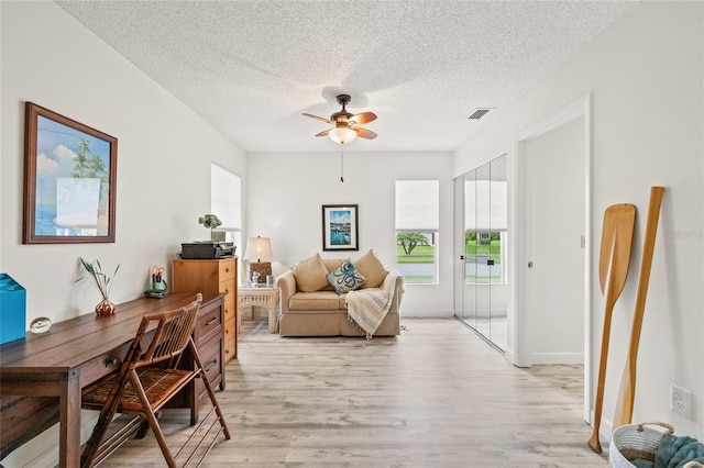 home office featuring ceiling fan, a textured ceiling, and light hardwood / wood-style flooring