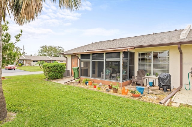 rear view of house with a sunroom and a yard