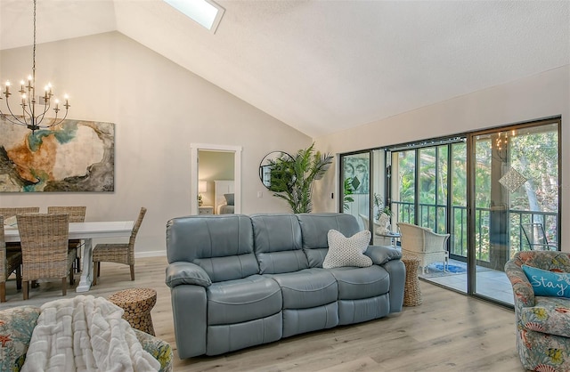 living room featuring high vaulted ceiling, a notable chandelier, and light hardwood / wood-style flooring