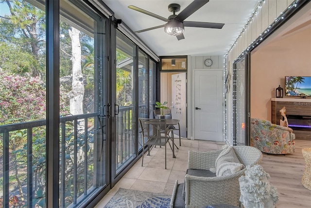 sunroom / solarium featuring ceiling fan