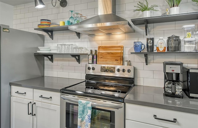 kitchen featuring wall chimney exhaust hood, decorative backsplash, white cabinets, and stainless steel appliances