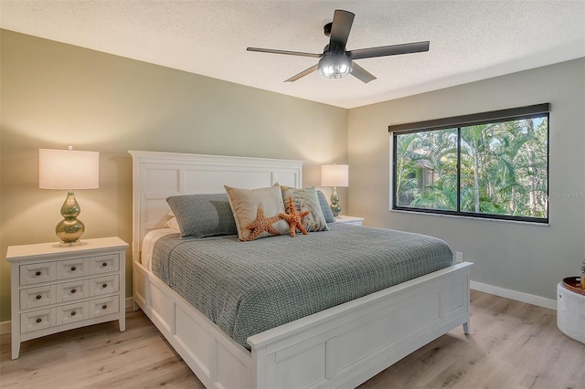 bedroom featuring a textured ceiling, light hardwood / wood-style floors, and ceiling fan