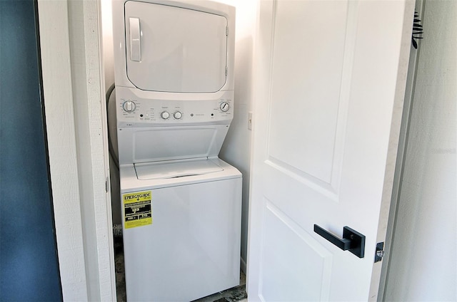 clothes washing area with stacked washing maching and dryer