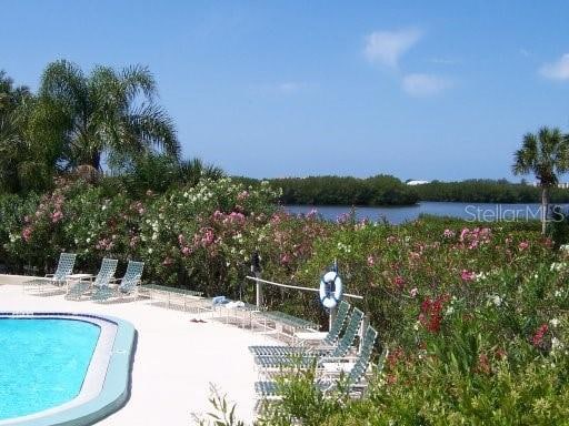 view of pool with a water view and a patio