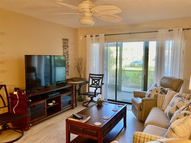 living room featuring ceiling fan and a textured ceiling