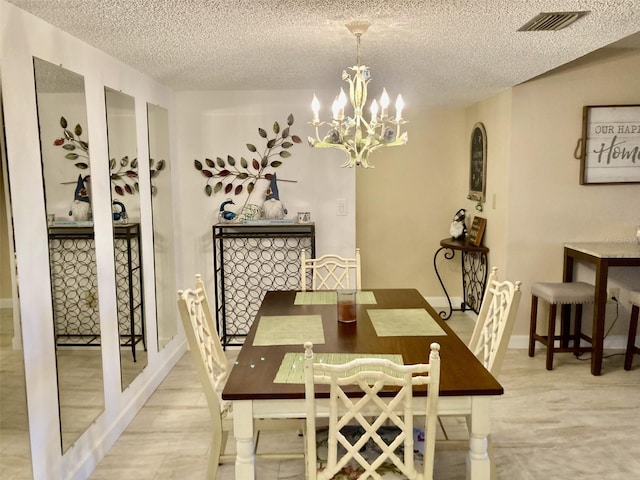 dining space featuring a notable chandelier and a textured ceiling