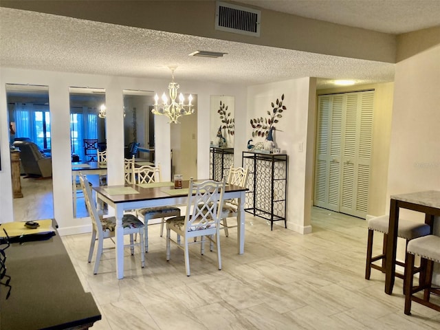 dining space with a notable chandelier and a textured ceiling