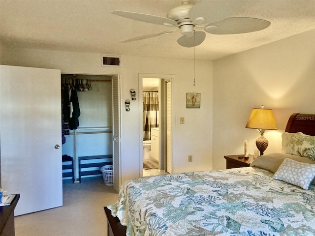 carpeted bedroom with a closet, a textured ceiling, ensuite bathroom, and ceiling fan