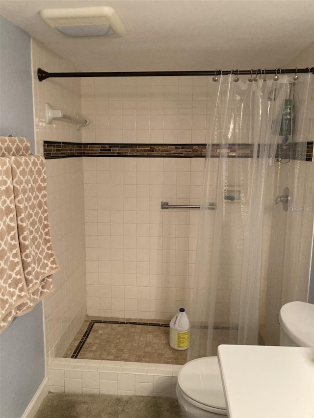 bathroom with toilet and a shower with curtain