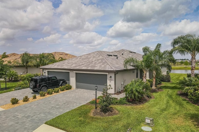 ranch-style house with a garage, a water view, and a front yard