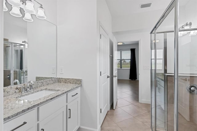 bathroom featuring vanity, tile patterned floors, and a shower with shower door