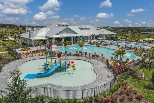 view of swimming pool featuring a patio area, a playground, and a water slide