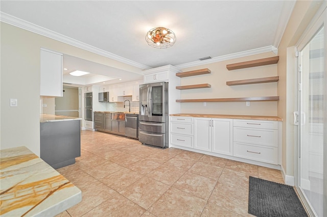 kitchen featuring appliances with stainless steel finishes, backsplash, crown molding, sink, and white cabinets