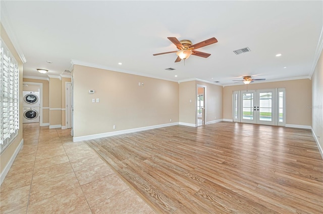 spare room with french doors, stacked washing maching and dryer, ornamental molding, ceiling fan, and light hardwood / wood-style flooring