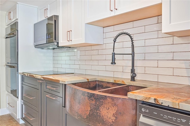 kitchen featuring decorative backsplash, sink, white cabinetry, and stainless steel appliances