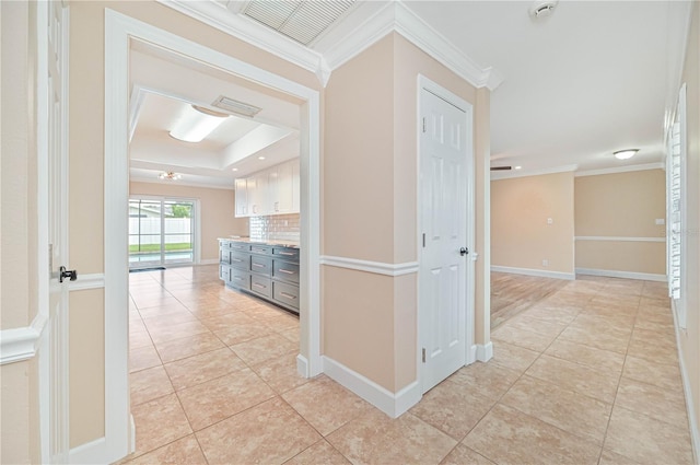 hallway featuring light tile patterned flooring and ornamental molding