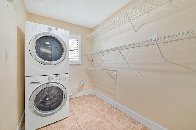 laundry area with tile patterned flooring and stacked washing maching and dryer