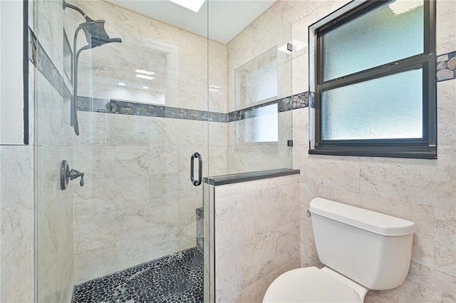 bathroom with toilet, an enclosed shower, and tile walls