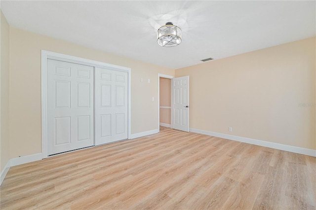 unfurnished bedroom with light hardwood / wood-style floors and a closet