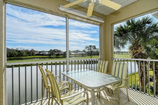 sunroom with a water view and ceiling fan