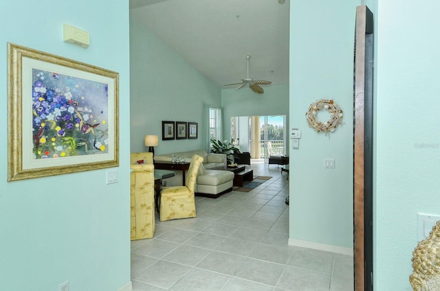 hall featuring light tile patterned floors and high vaulted ceiling