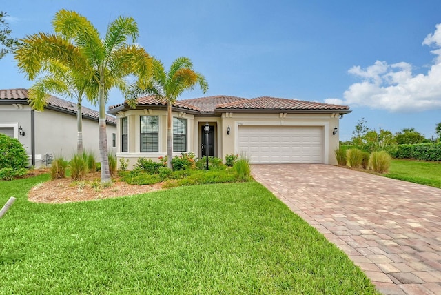 mediterranean / spanish house featuring a front lawn and a garage