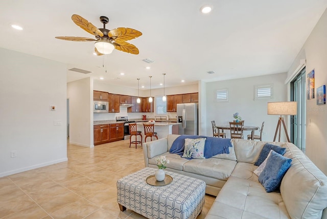 living room featuring ceiling fan, plenty of natural light, and light tile patterned floors